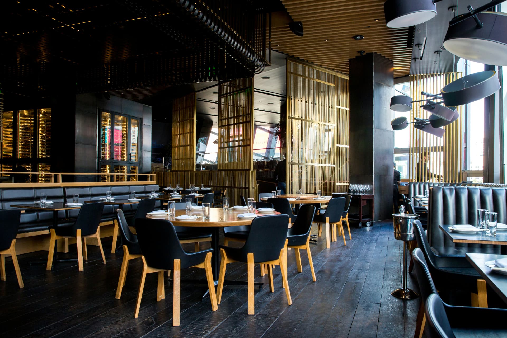 Dark, moody restaurant interior with wooden tables and warm gold lighting